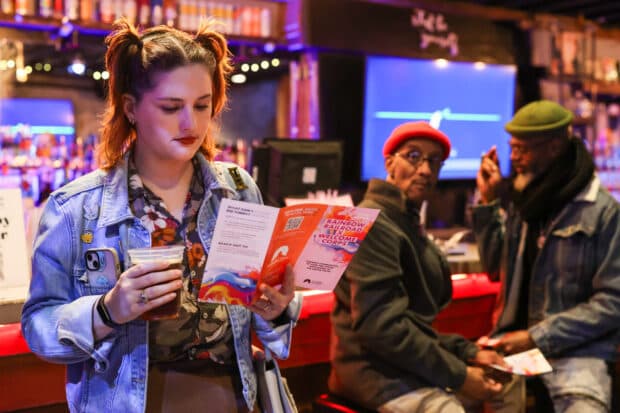 woman at bar reading pamphlet