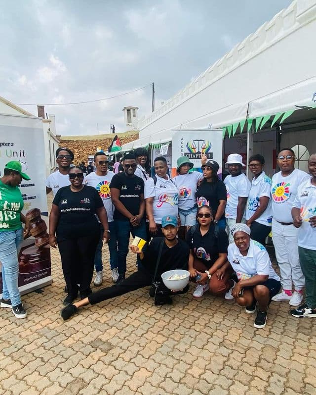 Group of people posing at an outdoor event with banners.