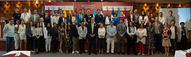 Large group photo of attendees at an LGBTIQ+ regional integration meeting with multiple country flags.