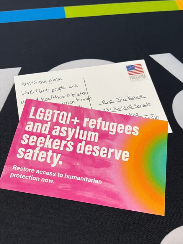 Postcard reading “LGBTQI+ refugees and asylum seekers deserve safety” beside a handwritten note.