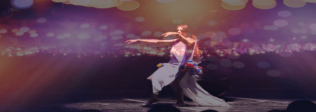 Person dancing on a stage with colourful lights.